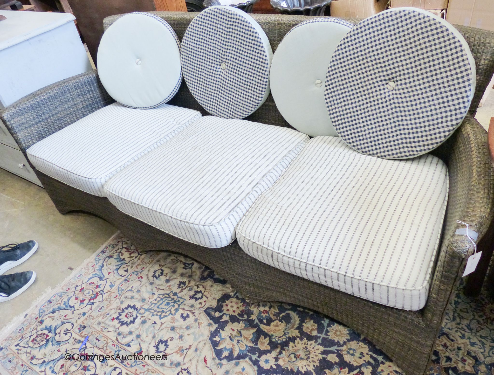 A contemporary all weather rattan three seater sofa and cushions. W-200cm, D-74cm, H-83cm.
